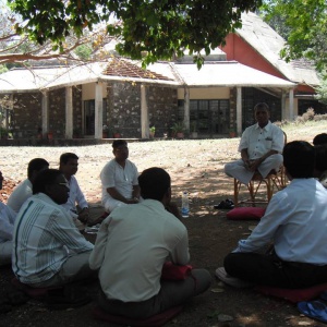 Dh. Anomdassi leading group discussion in open air under tree shade
