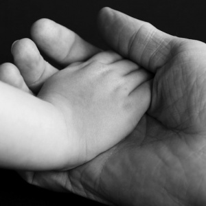 Child's hand in adult hand