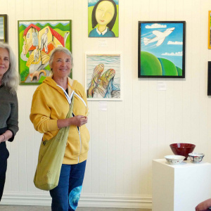 Kathleen (left) and Taralila (middle) with Suzie (sitting) at the opening - with David's paintings