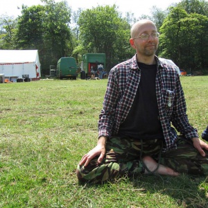 Leif (Site Crew) during lunchtime meditation. Base camp in the background.